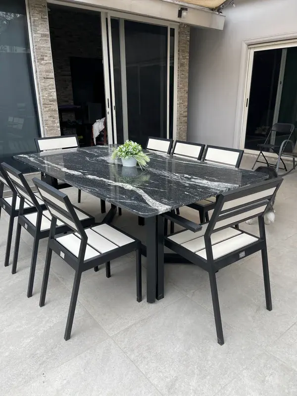 Sillas Mishka Garden alrededor de una mesa en una terraza, la del frente con antebrazos